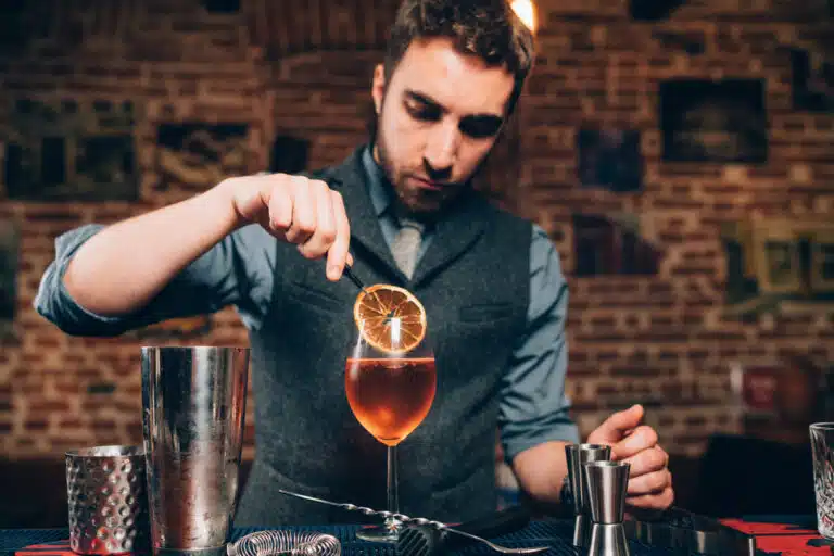 bartender preparing alcoholic aperitif, aperol spritz cocktail