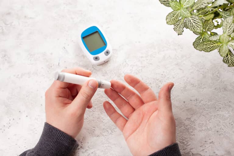 男子双手在手指上使用胰岛素来检查血糖或酮体